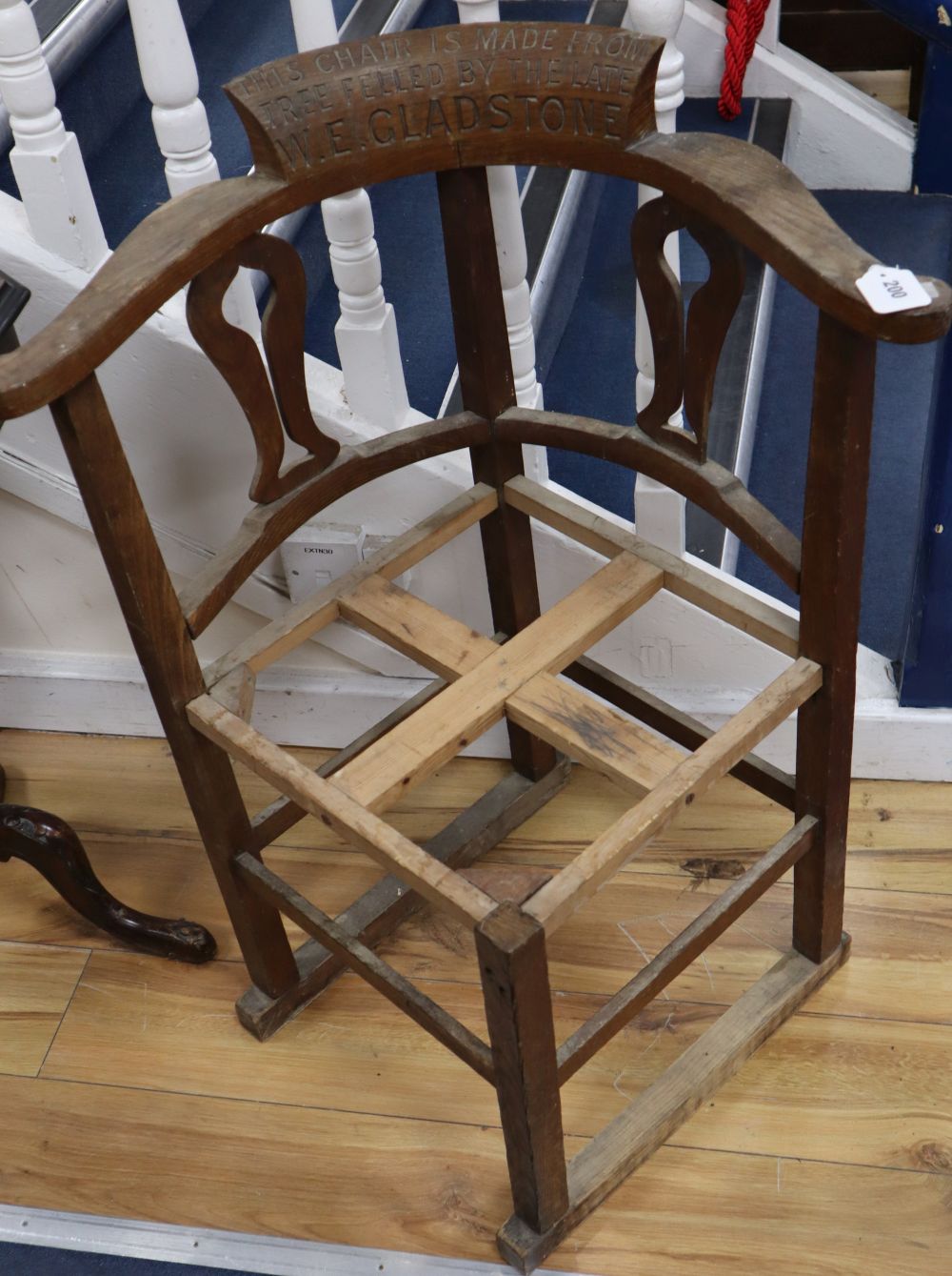 An early 20th century oak framed corner chair c.1900, inscribed This Chair is made from tree felled by the late W.E. Gladstone